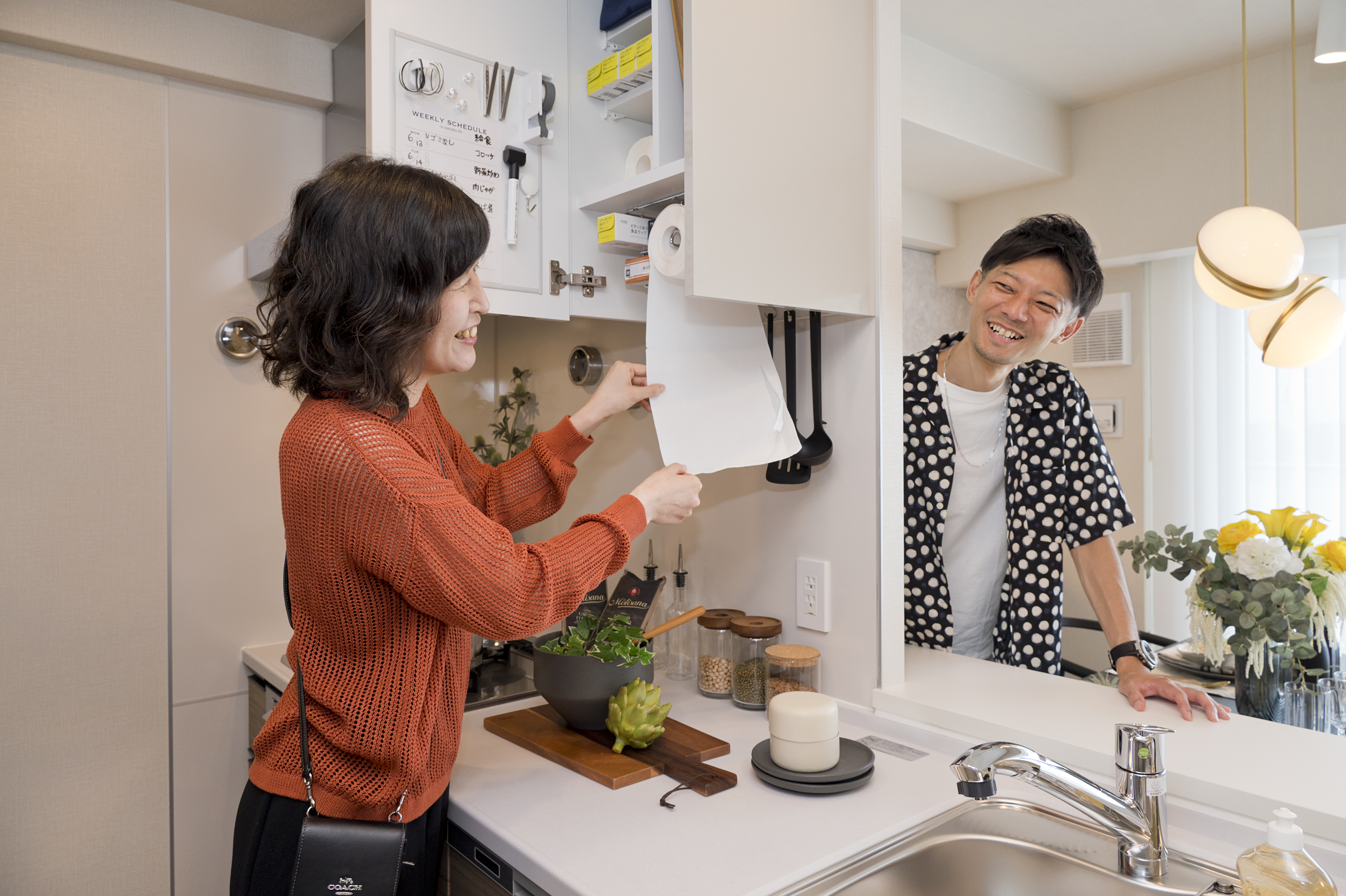 ラップやキッチンペーパーなどの収納スペースを備えた機能的なキッチンの吊戸棚※2